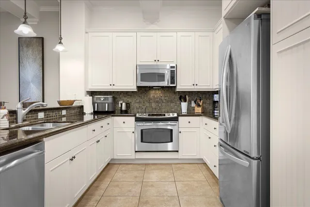 a kitchen with stainless steel appliances granite countertop a refrigerator and a stove top oven