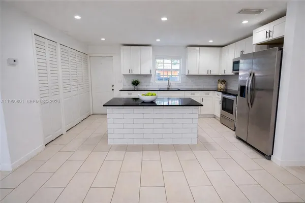 a kitchen with stainless steel appliances granite countertop a sink and a stove top oven