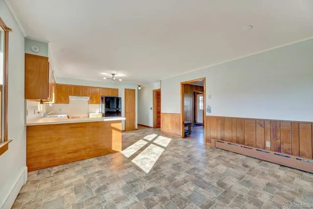 a view of a kitchen with kitchen island granite countertop a refrigerator and a sink