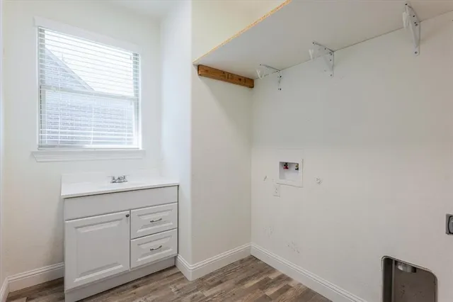 a bathroom with a sink a light fixture and a window