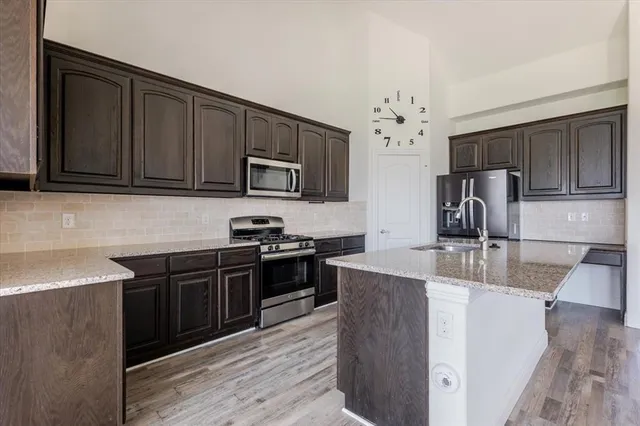a kitchen with stainless steel appliances granite countertop a sink stove and refrigerator