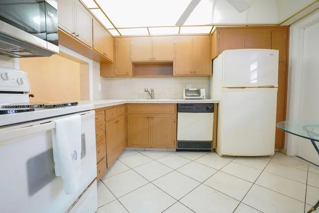 a kitchen with a refrigerator a stove a sink and cabinets
