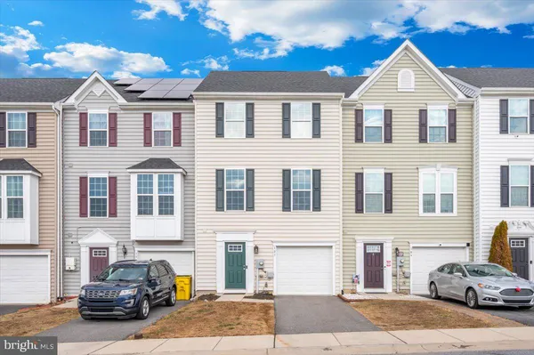 a front view of a house with cars parked