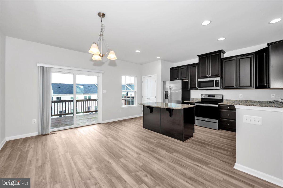 105 Montreal Way Falling Waters, WV 25419 - Photo 18 of 53 a kitchen with stainless steel appliances wooden floors wooden cabinets and a refrigerator