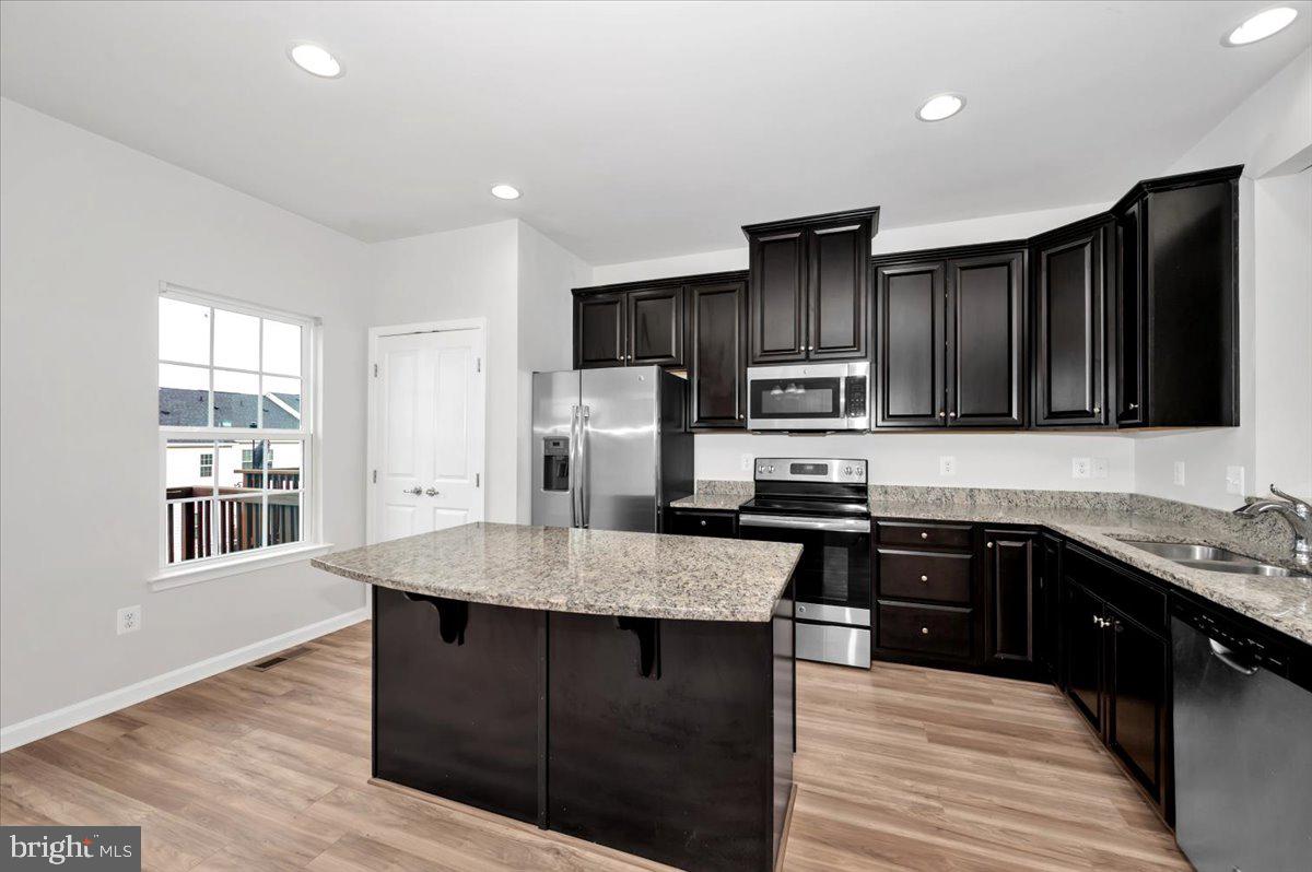 105 Montreal Way Falling Waters, WV 25419 - Photo 21 of 53 a kitchen with stainless steel appliances granite countertop a stove refrigerator and cabinets