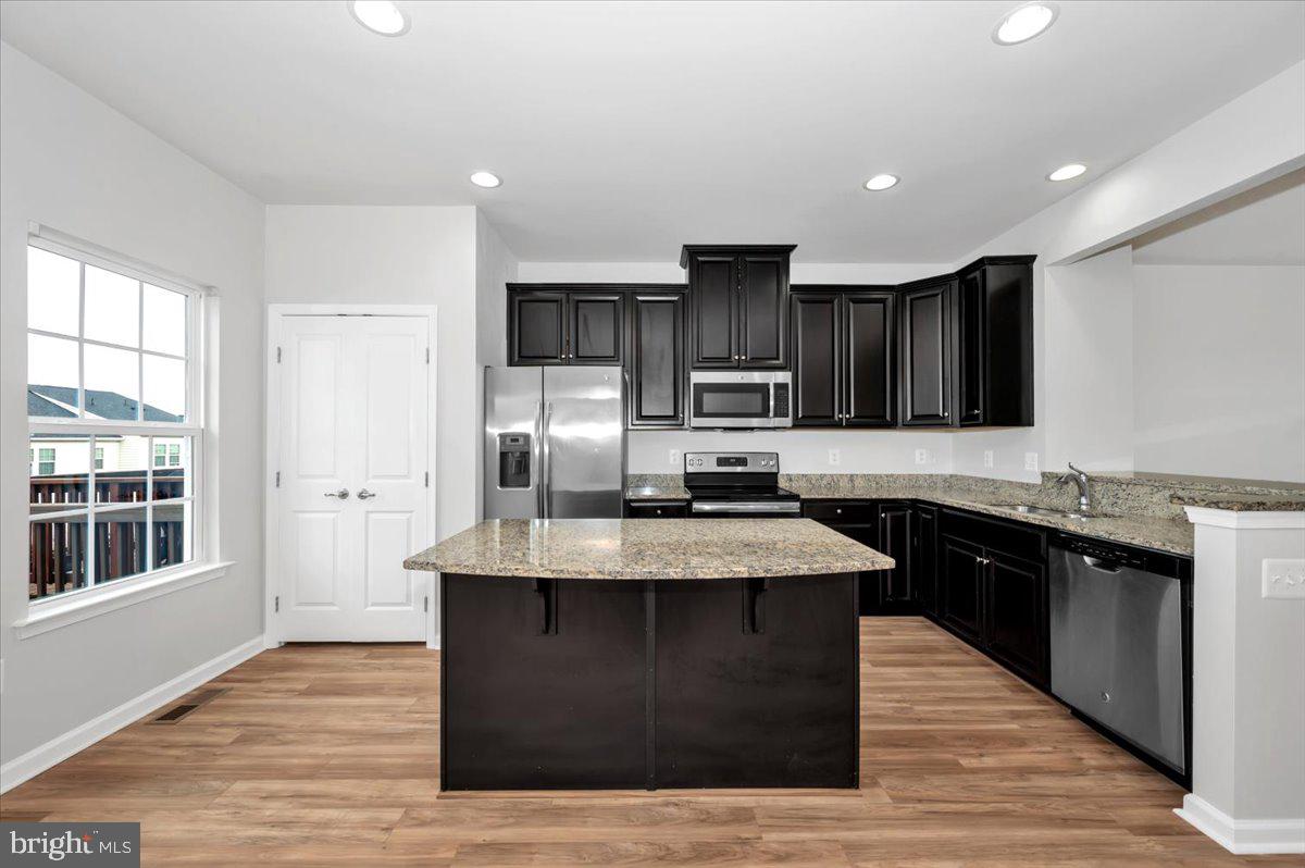 105 Montreal Way Falling Waters, WV 25419 - Photo 22 of 53 a kitchen with stainless steel appliances granite countertop a stove a sink dishwasher a refrigerator and a oven with wooden floor