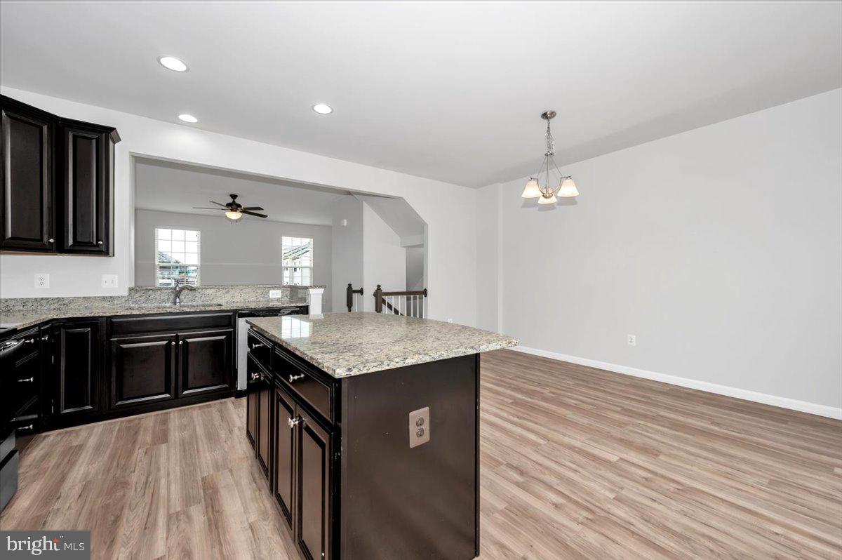 105 Montreal Way Falling Waters, WV 25419 - Photo 24 of 53 a kitchen with kitchen island granite countertop a stove top oven a sink and dishwasher with wooden floor