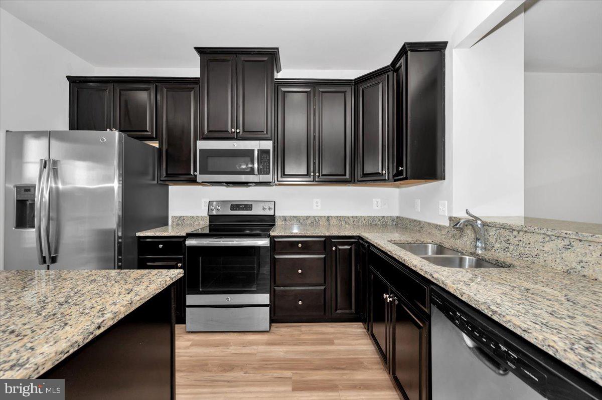 105 Montreal Way Falling Waters, WV 25419 - Photo 26 of 53 a kitchen with granite countertop stainless steel appliances and wooden cabinets