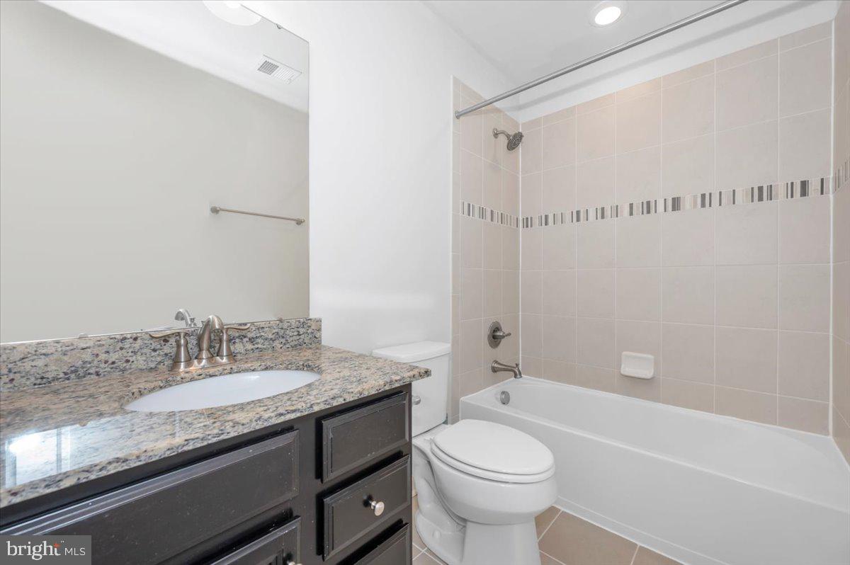 105 Montreal Way Falling Waters, WV 25419 - Photo 44 of 53 a bathroom with a granite countertop sink a toilet and shower