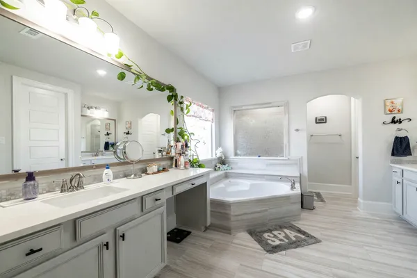 a spacious bathroom with a granite countertop sink a toilet and a mirror
