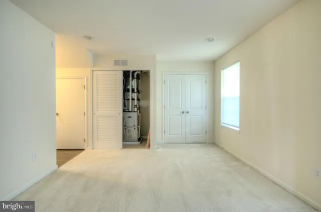 an empty room with closet and windows
