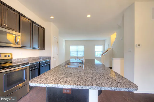 a kitchen with stainless steel appliances granite countertop a sink stove and cabinets
