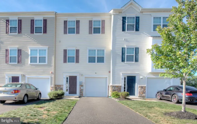 a front view of a house with a garden and parking