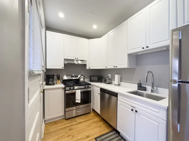 a kitchen with a sink a stove and cabinets
