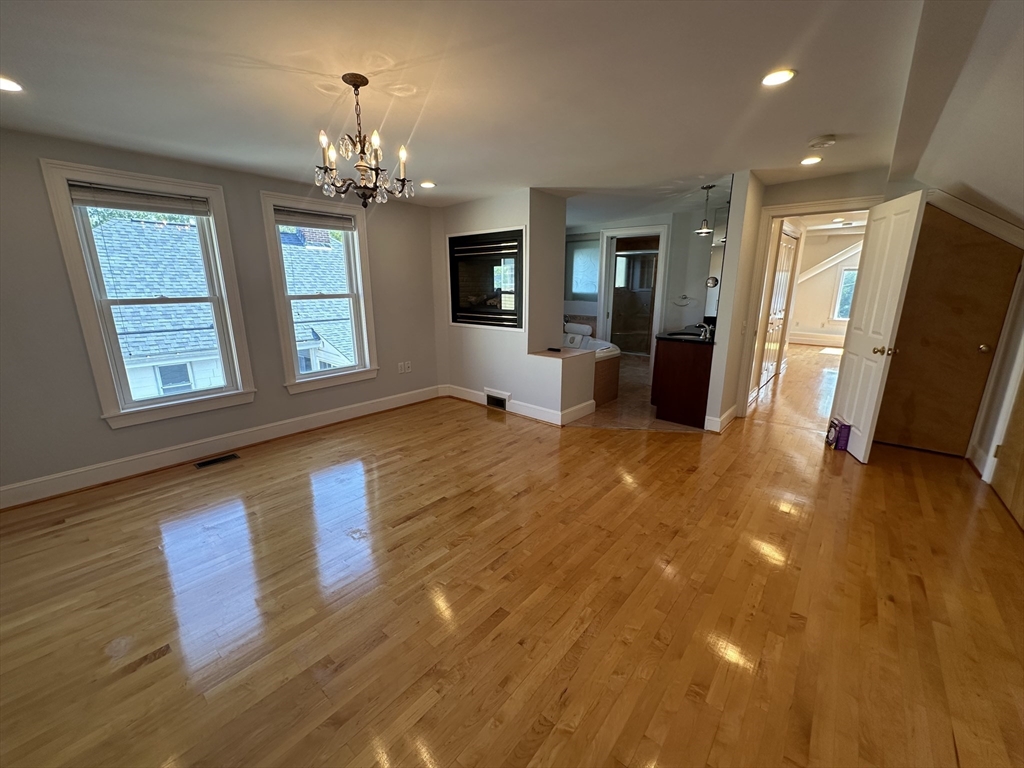17 Herbert Road, Unit 1 Arlington, MA 02474 - Photo 22 of 26 a view of a livingroom with wooden floor and a kitchen space
