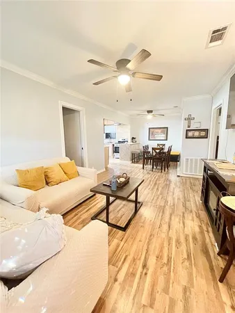 a living room with furniture and a wooden floor