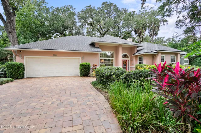 a front view of house with yard and trees around
