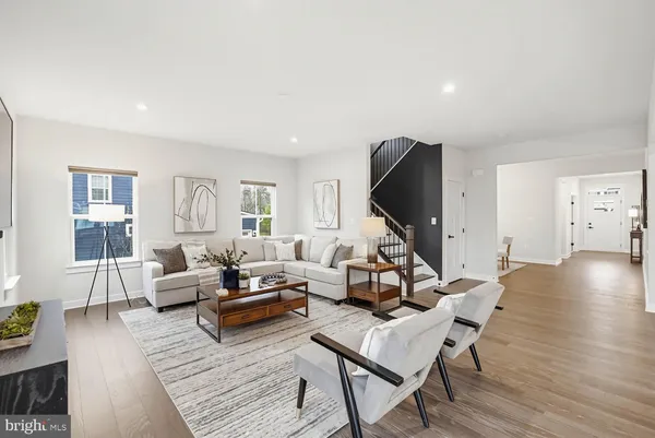 a living room with furniture a flat screen tv and wooden floor