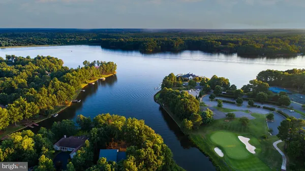 an aerial view of residential houses with outdoor space and a lake view