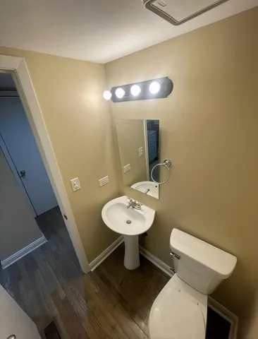 a bathroom with a toilet a sink and mirror