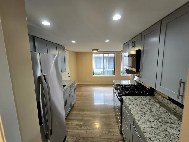 a kitchen with stainless steel appliances granite countertop a refrigerator and a stove