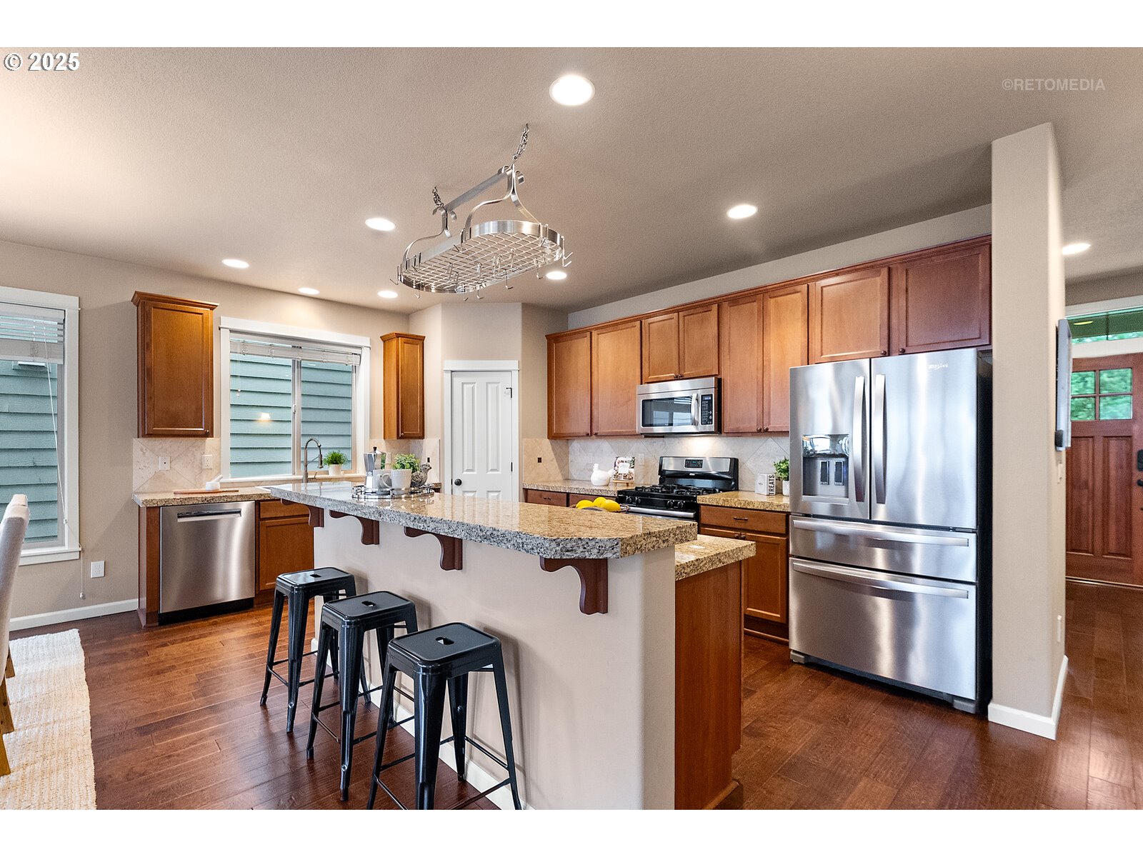 865 Southwest 90th Avenue Portland, OR 97225 - Photo 9 of 36 a kitchen with stainless steel appliances kitchen island granite countertop a refrigerator a stove a sink a dining table and chairs
