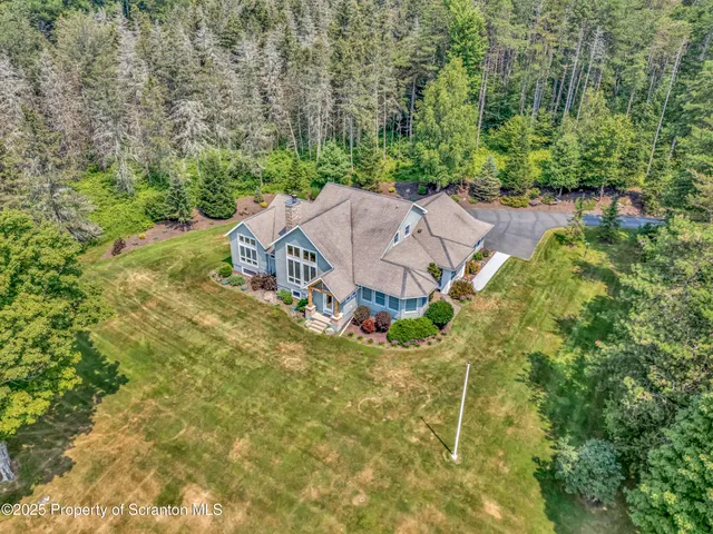 an aerial view of a house with yard swimming pool and outdoor seating