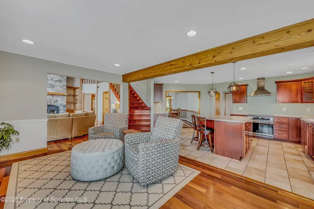 a view of a dining room with furniture a chandelier and a window