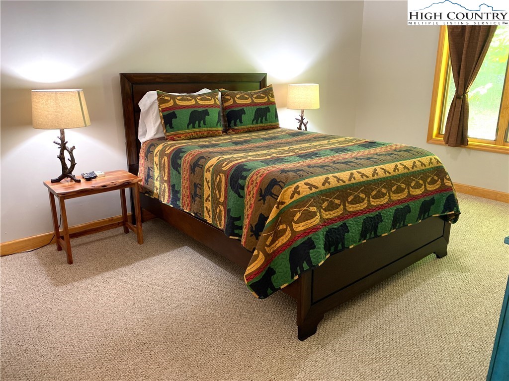 402 Pinnacle Ridge Road Beech Mountain, NC 28604 - Photo 14 of 44 a bed sitting in a bedroom next to a lamp