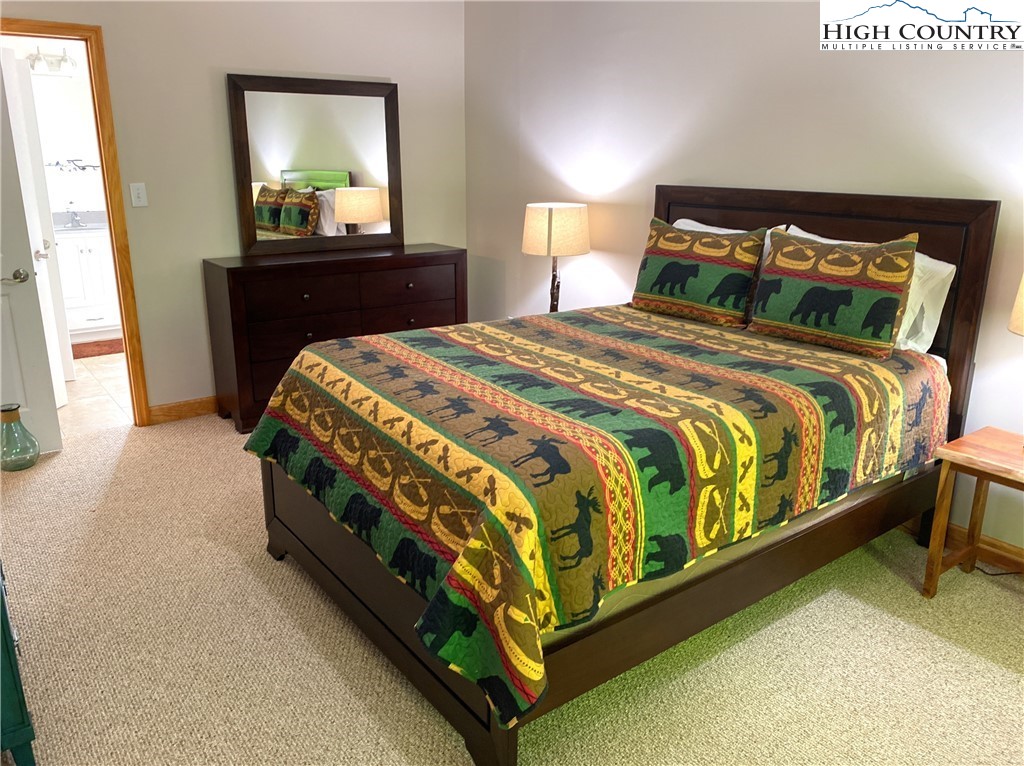 402 Pinnacle Ridge Road Beech Mountain, NC 28604 - Photo 15 of 44 a bedroom with a bed and a mirror on dresser