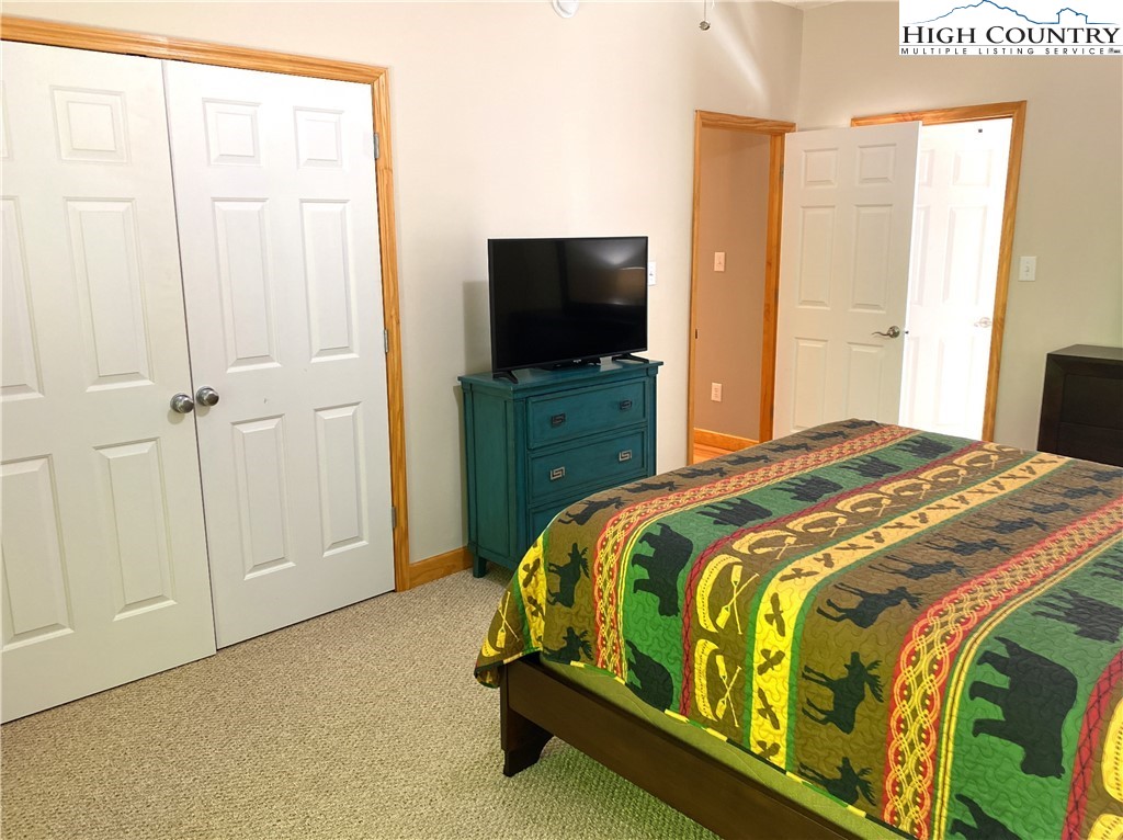 402 Pinnacle Ridge Road Beech Mountain, NC 28604 - Photo 16 of 44 a bedroom with a bed and a flat screen tv