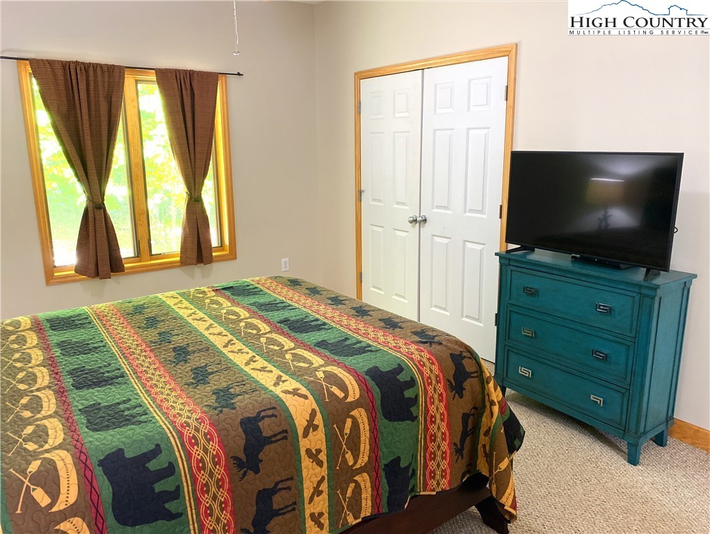 402 Pinnacle Ridge Road Beech Mountain, NC 28604 - Photo 17 of 44 a bedroom with a bed and a flat screen television