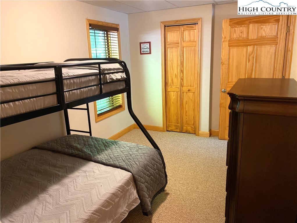 402 Pinnacle Ridge Road Beech Mountain, NC 28604 - Photo 35 of 44 a bedroom with a bed a dresser next to a window