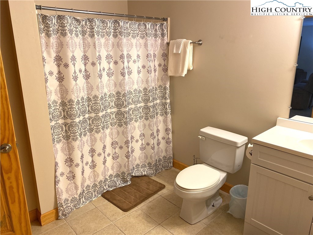 402 Pinnacle Ridge Road Beech Mountain, NC 28604 - Photo 39 of 44 a white toilet sitting next to a shower curtain