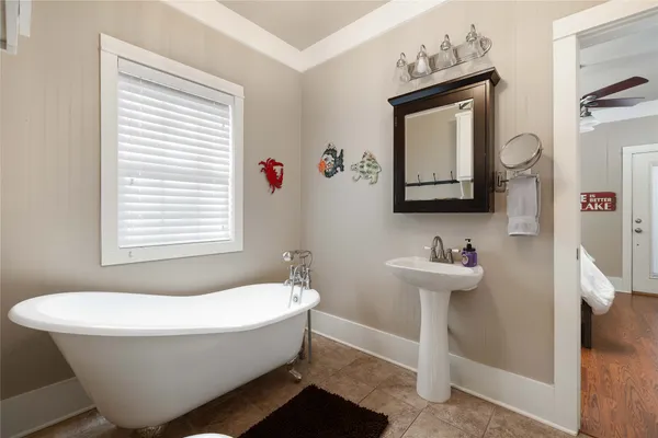 a bathroom with a bathtub sink and mirror