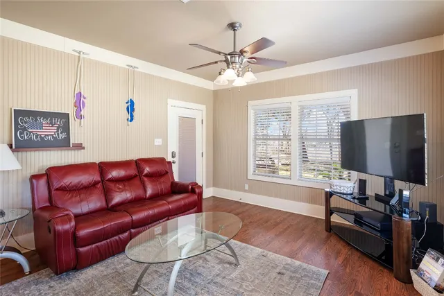 a living room with furniture a flat screen tv and a large window