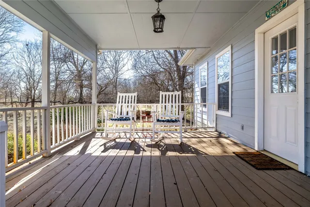a view of a deck with wooden floor and fence next to a yard