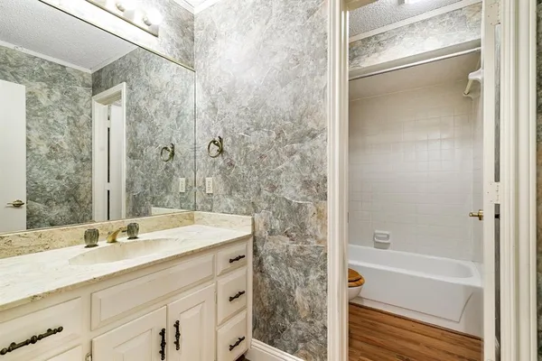 a bathroom with a shower sink vanity and mirror
