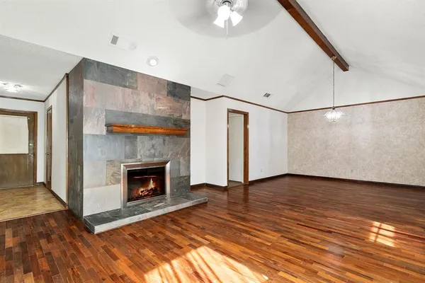 a view of a livingroom with wooden floor and a fireplace