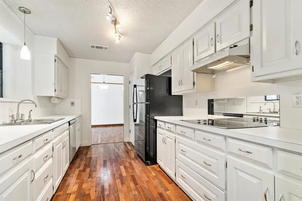a kitchen with kitchen island granite countertop a sink stainless steel appliances and cabinets