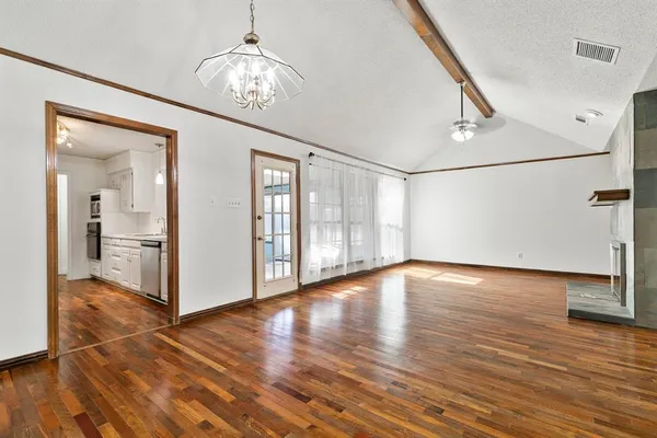 a view of a hallway with wooden floor and a chandelier