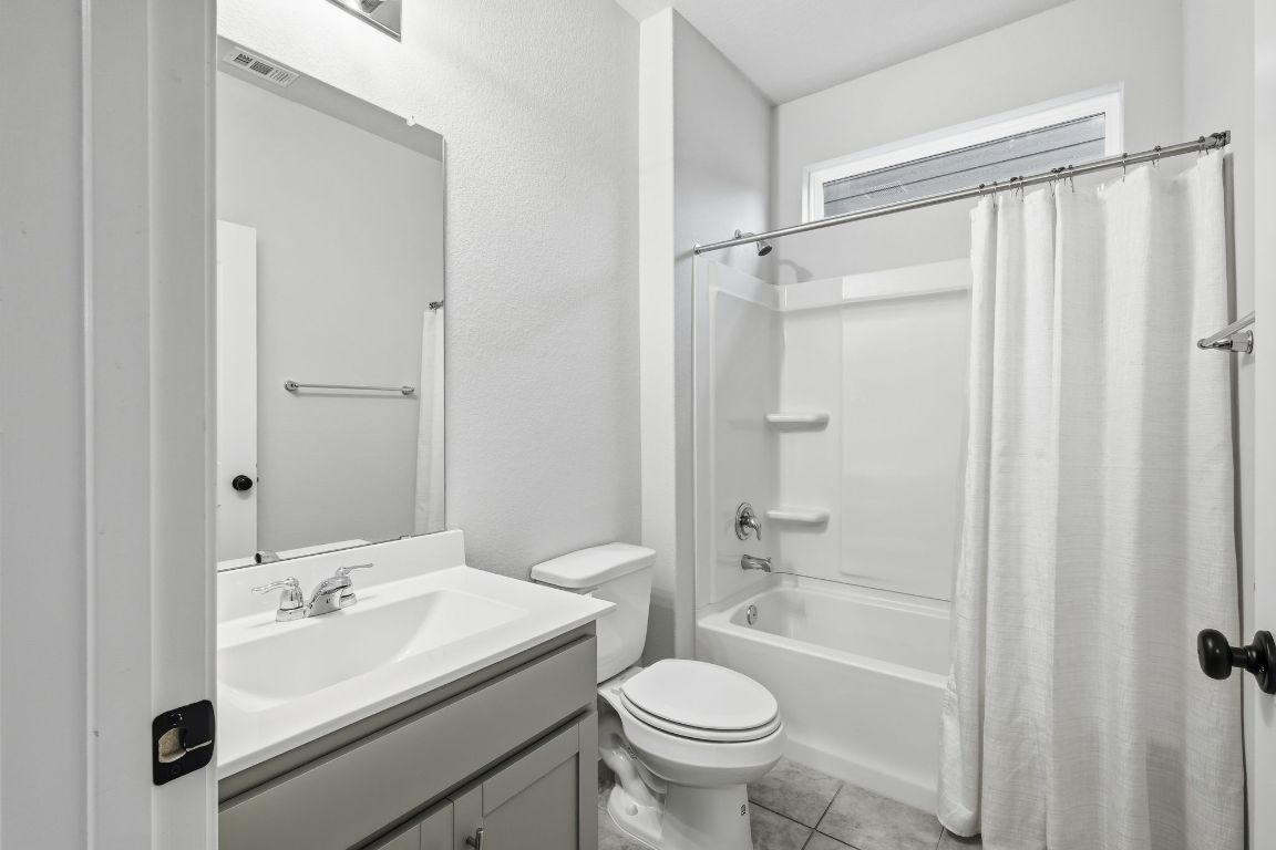 1941 Winston Way Leander, TX 78641 - Photo 11 of 28 Bathroom featuring shower / bath combo, vanity, and light tile patterned floors