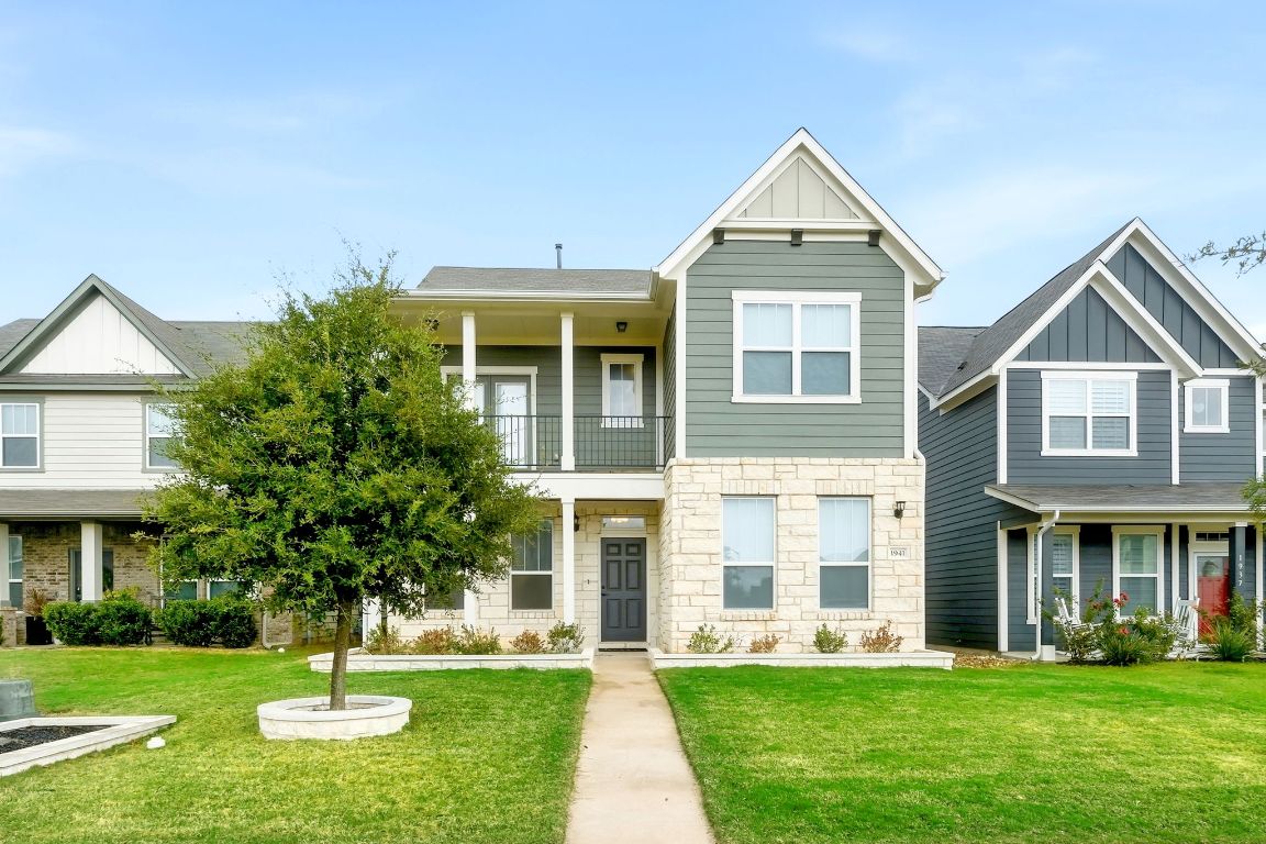 1941 Winston Way Leander, TX 78641 - Photo 2 of 28 View of front of home with board and batten siding, a front yard, a balcony, and stone siding