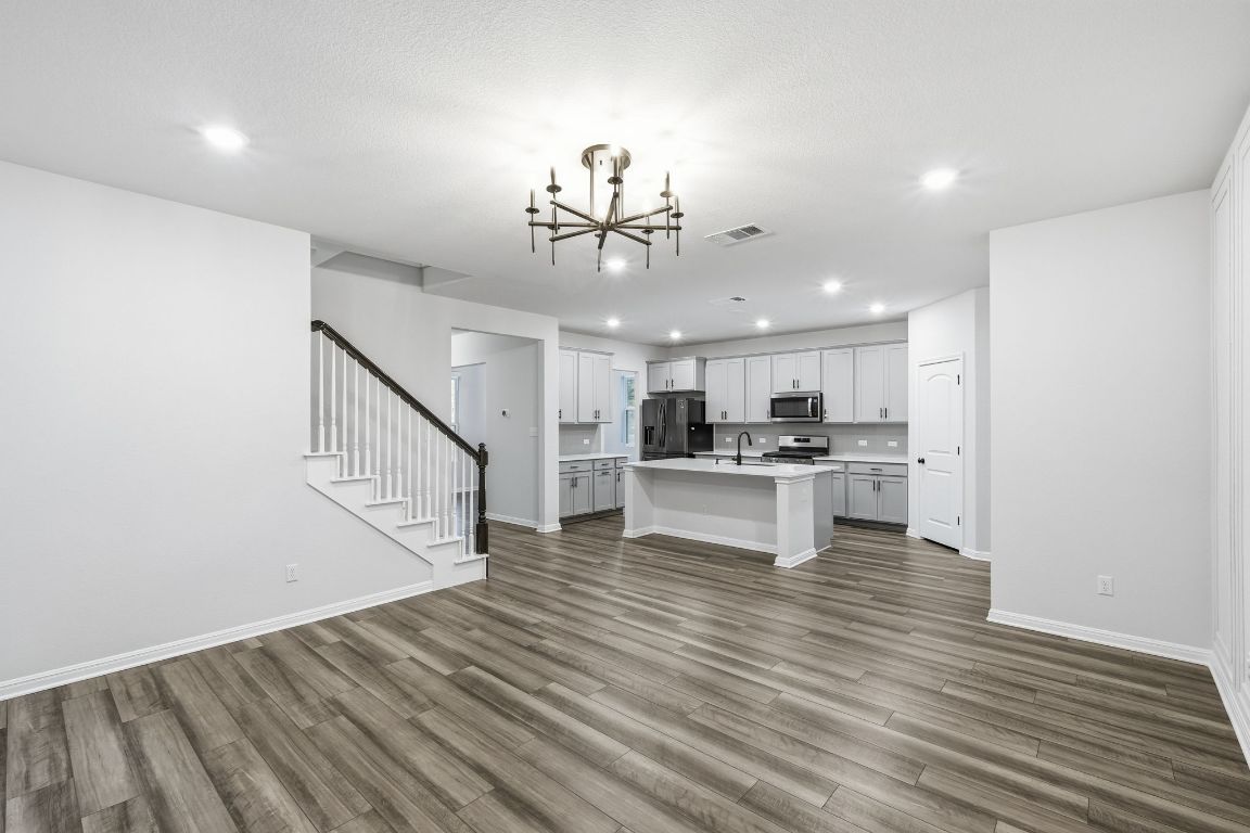 1941 Winston Way Leander, TX 78641 - Photo 28 of 28 Kitchen with open floor plan, a chandelier, a center island with sink, recessed lighting, and dark wood finished floors