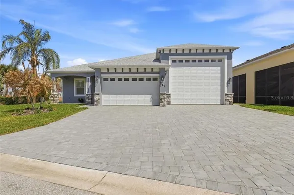 a view of a house with a yard and potted plants