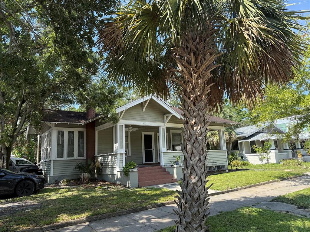 a front view of a house with garden and trees