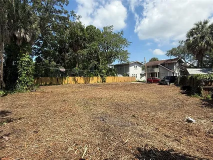 a view of a yard with wooden fence
