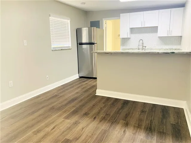 a view of a kitchen with wooden floor and a sink