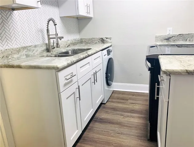 a kitchen with a sink stove and cabinets