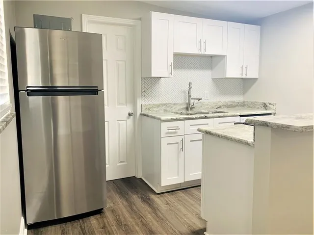 a kitchen with stainless steel appliances granite countertop a refrigerator and a stove